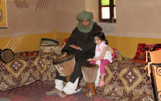 Kind en Berber spelen op traditionele drums in Marokko