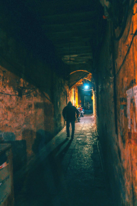 man walking in dark alley
